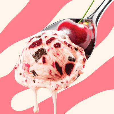 Pint of N!CK'S Cherry Chocolate light ice cream. The label highlights 'no added sugar' and '350 calories/pint'. A spoon holds a scoop of ice cream with cherry pieces and chocolate chunks, topped with a fresh cherry.